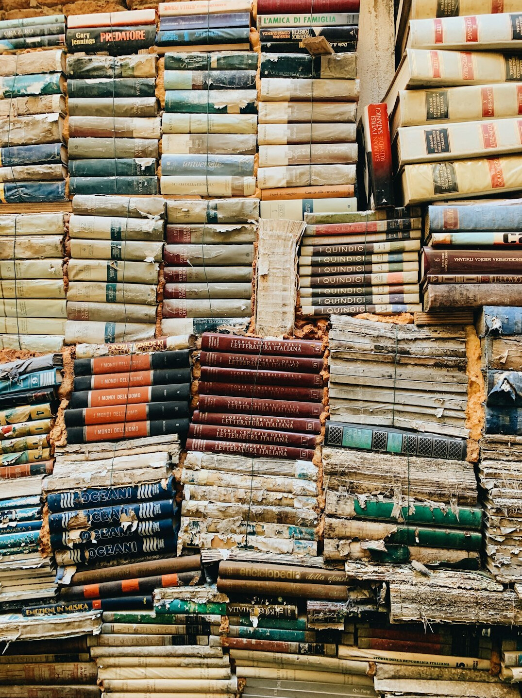 Pile of old hardcover books with worn spines