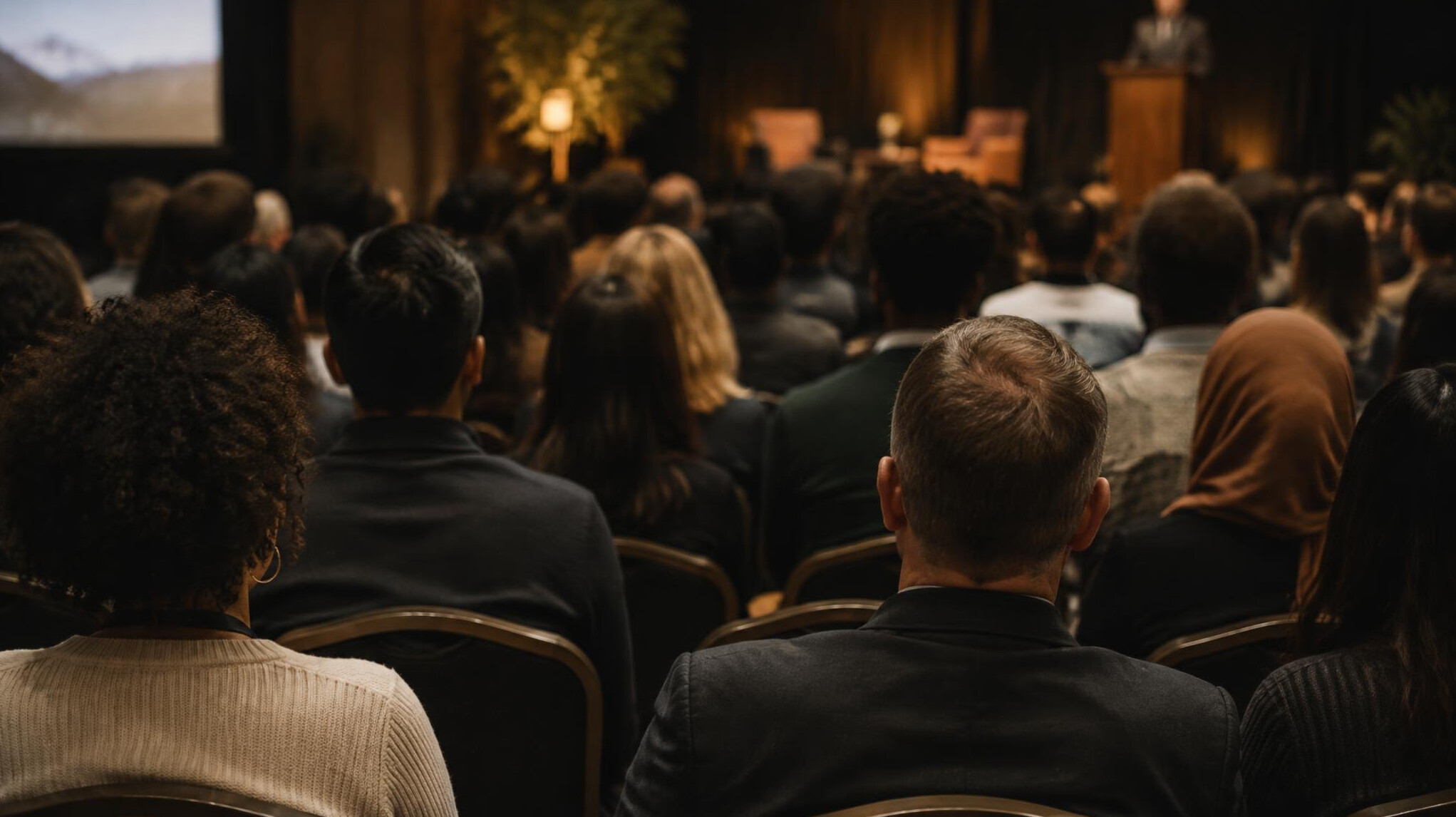 Audience seated in a conference hall seen from behind