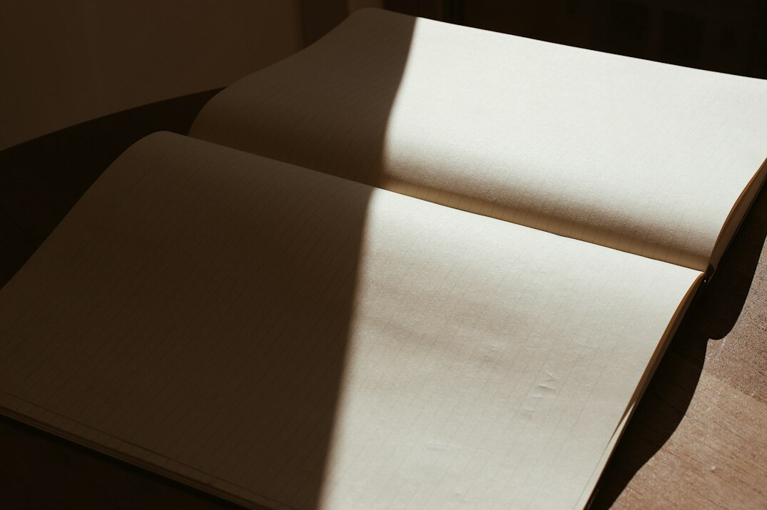 Open notebook with handwritten notes beside a cup on a desk
